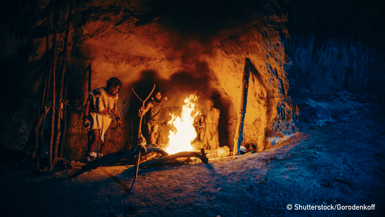 Tribe of Prehistoric Hunter-Gatherers Wearing Animal Skins Stand Around Bonfire Outside of Cave at Night. Portrait of Neanderthal / Homo Sapiens Family Doing Pagan Religion Ritual Near Fire