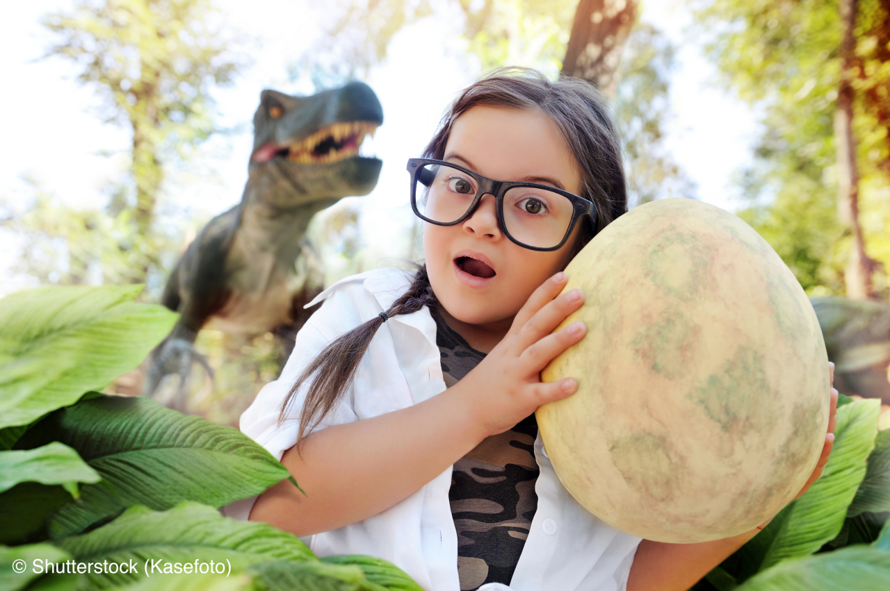 Little girl holding dinosaur egg in hands
