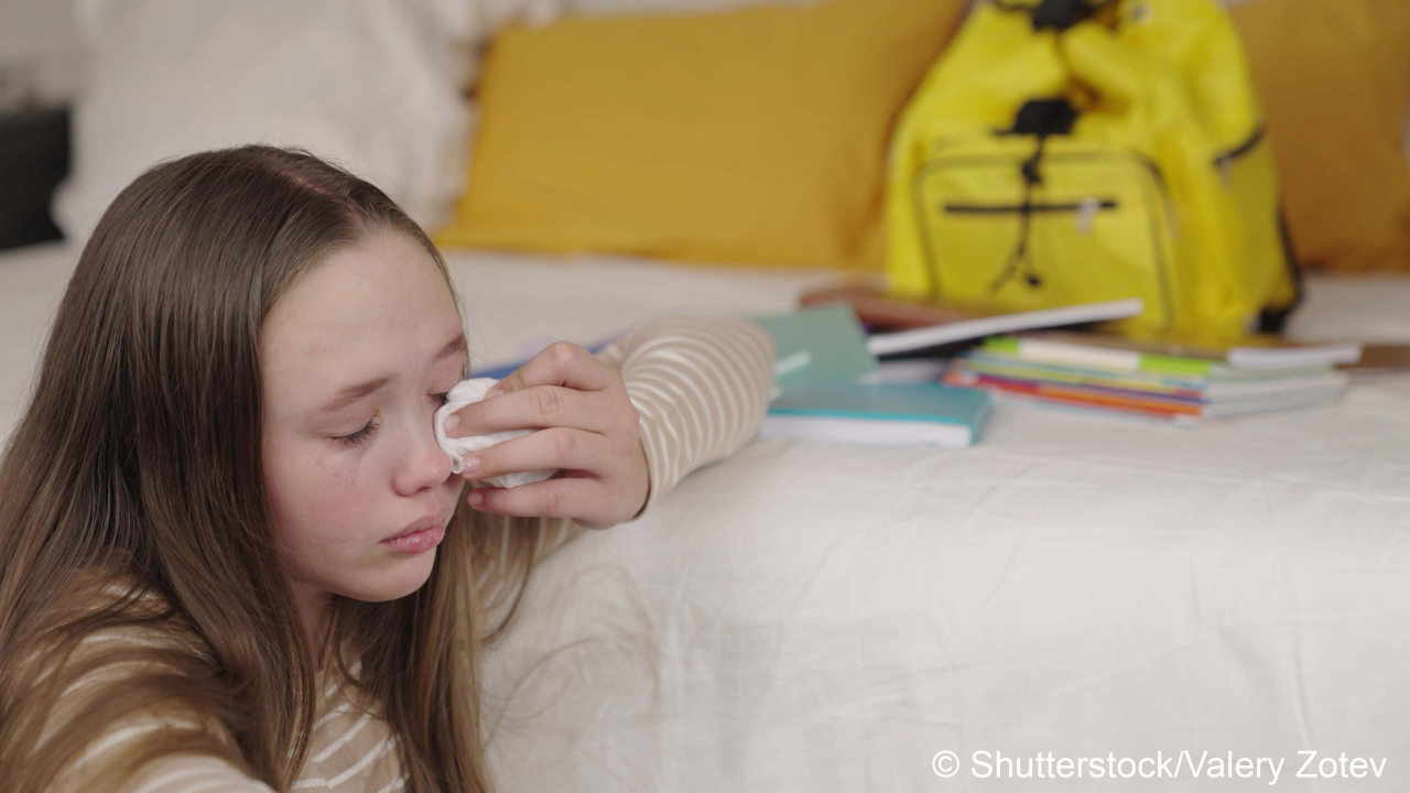 teenage girl crying wiping tears from wet eyes on her face, school difficulties upset child, resentment relationships with peers, psycho kid whims, sadness and loneliness with textbooks and backpack