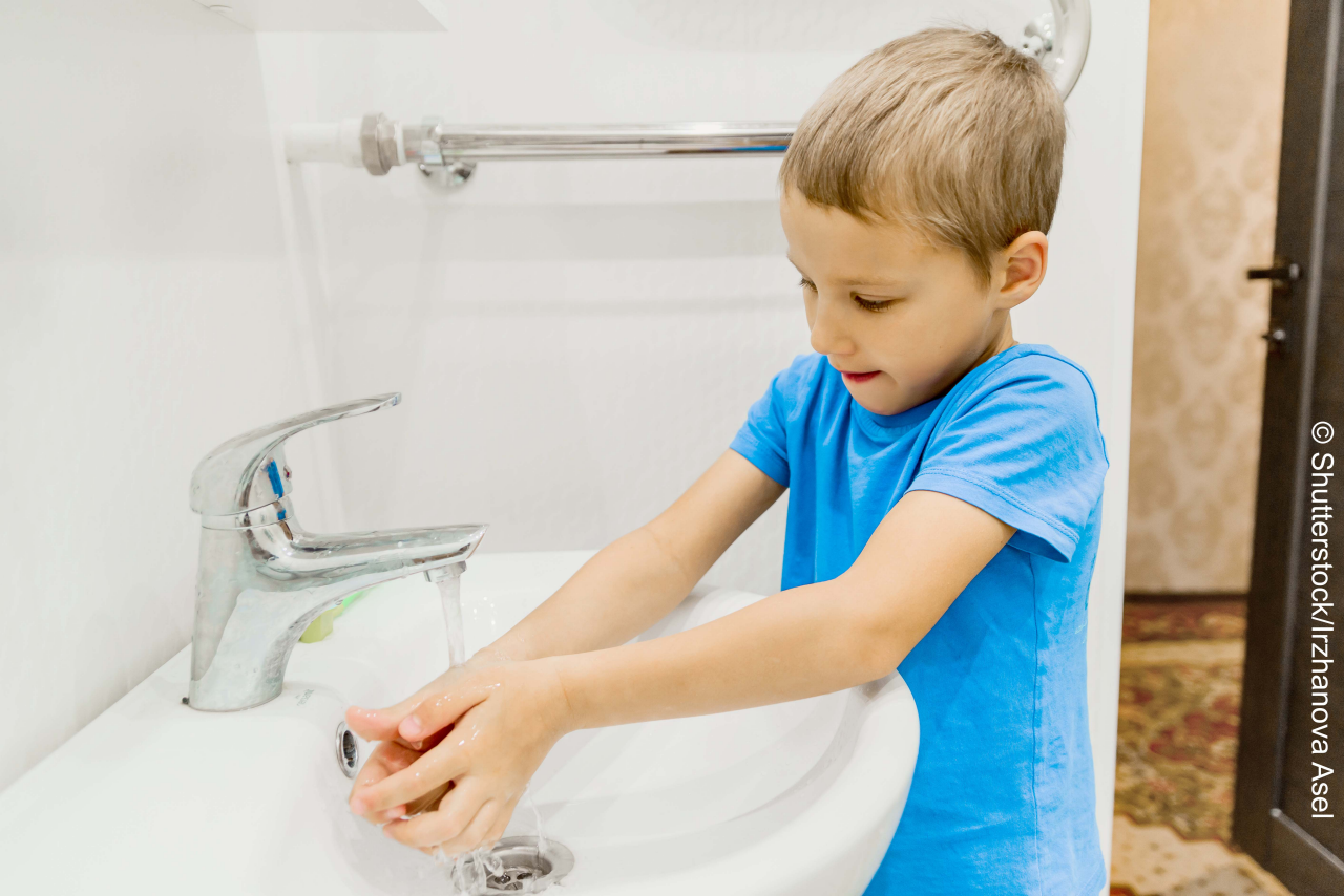 The child washes his hands in the bathroom.  wash hands with soap close-up. concept of hygiene and cleanliness. tap water