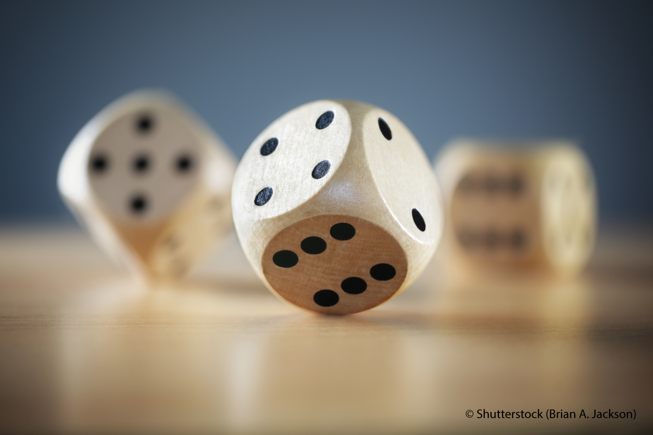 Rolling three dice on a wooden desk